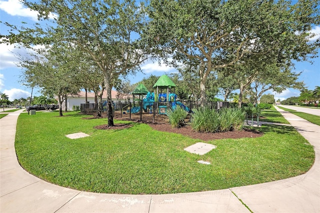 view of property's community with a playground and a yard