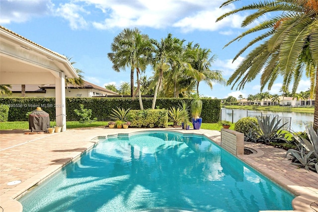 view of pool featuring a water view and a patio