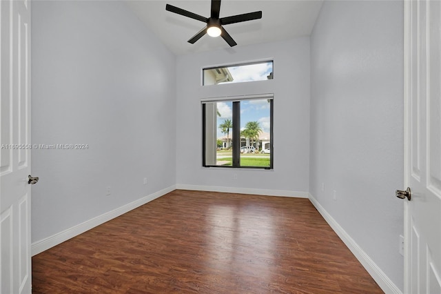 spare room with dark hardwood / wood-style flooring, vaulted ceiling, and ceiling fan