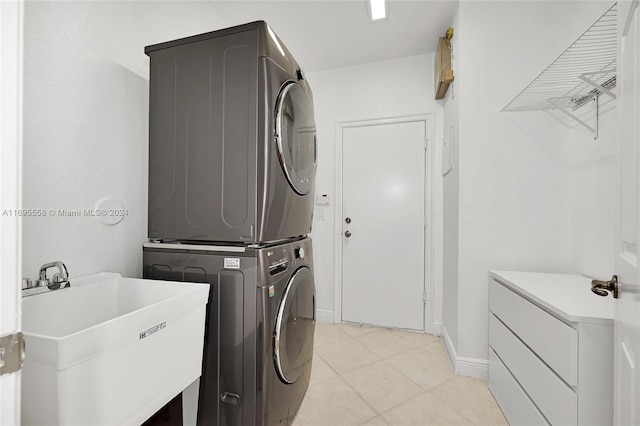 clothes washing area with sink and stacked washer and clothes dryer