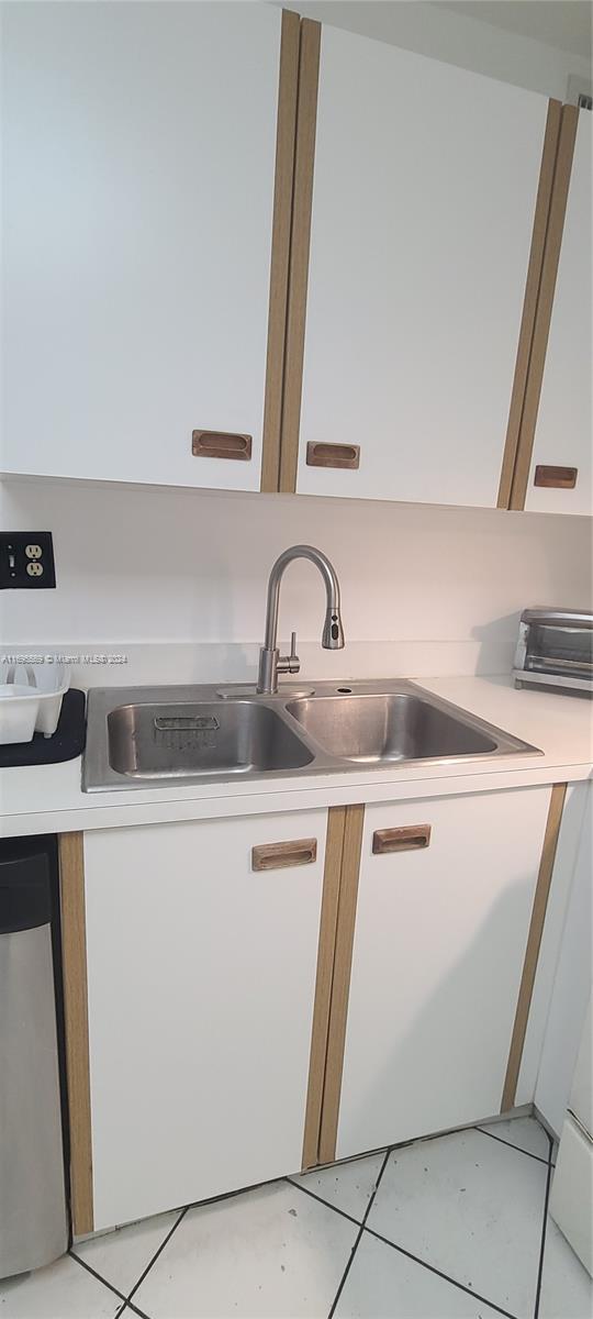 3564 Magellan Cir Unit 211-1, Aventura, FL 33180 - kitchen featuring a sink, stainless steel dishwasher, light countertops, and white cabinets