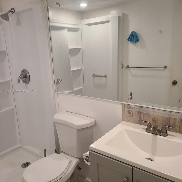 bathroom with vanity, toilet, and walk in shower