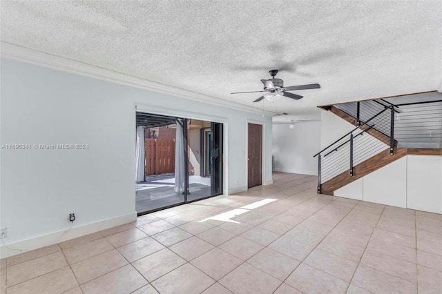 tiled spare room with ceiling fan and a textured ceiling