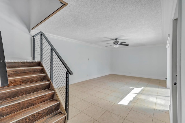 stairs featuring tile patterned flooring, a textured ceiling, ceiling fan, and ornamental molding