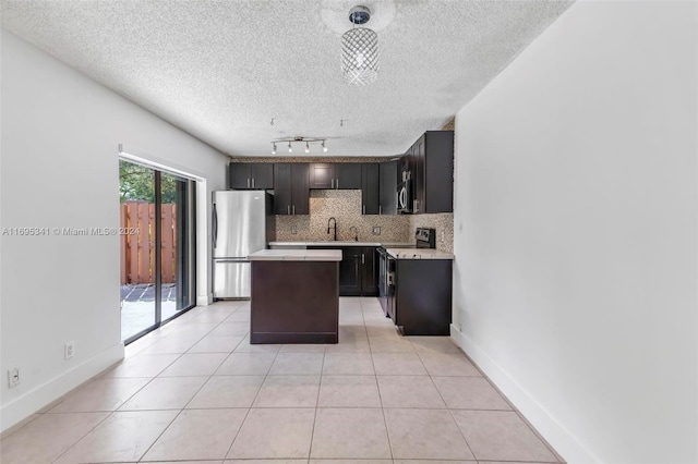 kitchen featuring dark brown cabinetry, a center island, sink, stainless steel appliances, and a textured ceiling