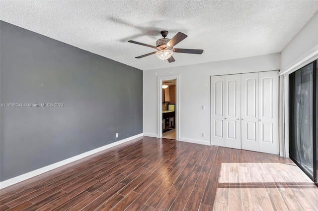 unfurnished bedroom with a textured ceiling, dark hardwood / wood-style flooring, ceiling fan, and connected bathroom