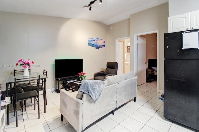 living room with light tile patterned flooring, rail lighting, and vaulted ceiling