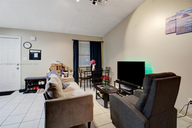 living room with light tile patterned floors and lofted ceiling