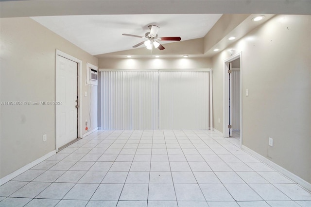 tiled spare room with vaulted ceiling, ceiling fan, and an AC wall unit