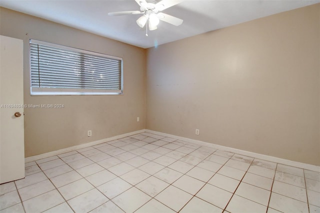 spare room with ceiling fan and light tile patterned floors