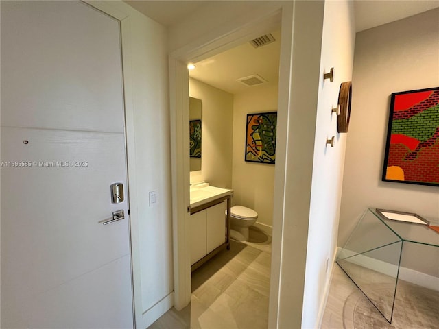 bathroom featuring toilet and vanity