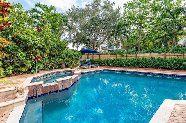 view of swimming pool with an in ground hot tub