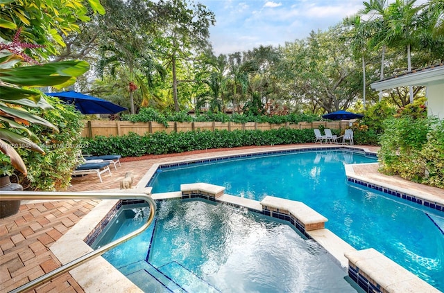 view of pool featuring an in ground hot tub