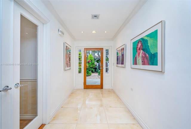 entryway featuring crown molding and light tile patterned floors