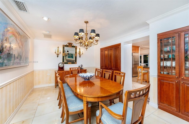 dining room with light tile patterned floors, ornamental molding, and an inviting chandelier