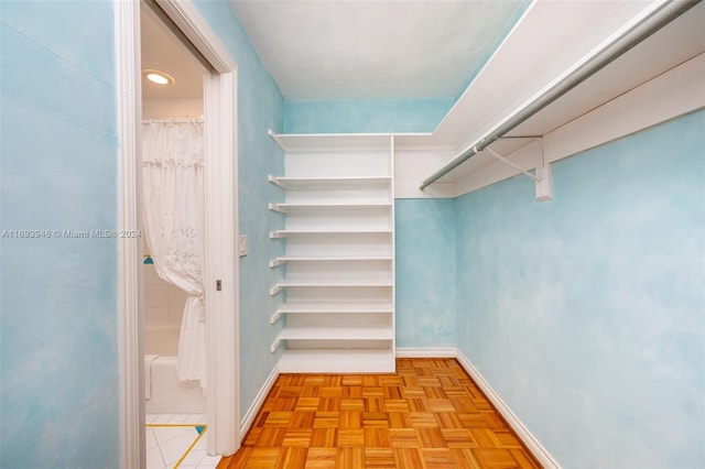 walk in closet with light parquet flooring