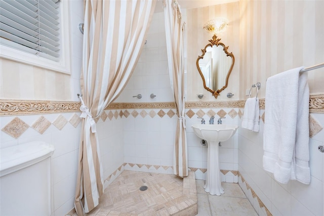 bathroom featuring toilet and tile walls