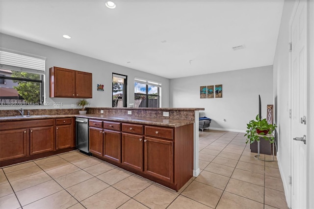 kitchen featuring a healthy amount of sunlight, kitchen peninsula, sink, and light tile patterned floors