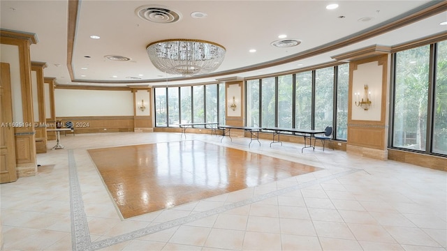 interior space with crown molding, a tray ceiling, and light tile patterned floors