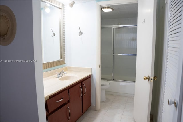 full bathroom featuring vanity, tile patterned floors, enclosed tub / shower combo, and toilet