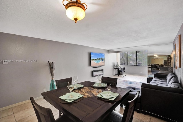 dining area with ceiling fan, light tile patterned floors, and a textured ceiling