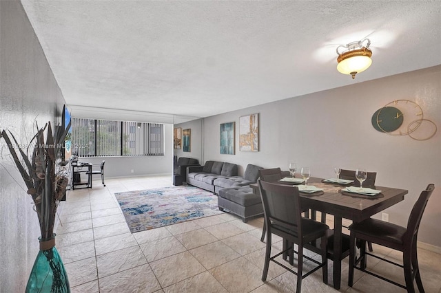 tiled dining space with a textured ceiling