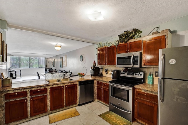 8010 Hampton Blvd Unit 211, North Lauderdale, FL 33068 - kitchen with appliances with stainless steel finishes, light tile patterned floors, a textured ceiling, tasteful backsplash, and dark brown cabinets