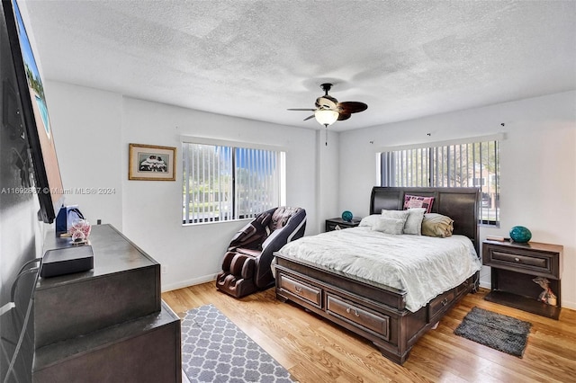 bedroom featuring ceiling fan, a textured ceiling, and light wood-type flooring