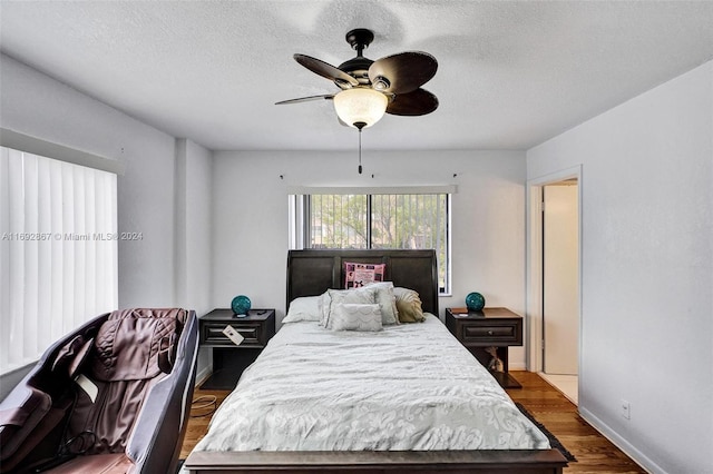 bedroom featuring a textured ceiling, ceiling fan, and dark wood-type flooring