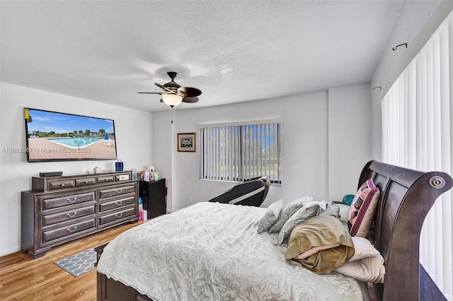 8010 Hampton Blvd Unit 211, North Lauderdale, FL 33068 - bedroom featuring light wood-style flooring, a ceiling fan, multiple windows, and a textured ceiling