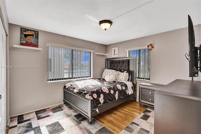 bedroom featuring hardwood / wood-style floors and a textured ceiling