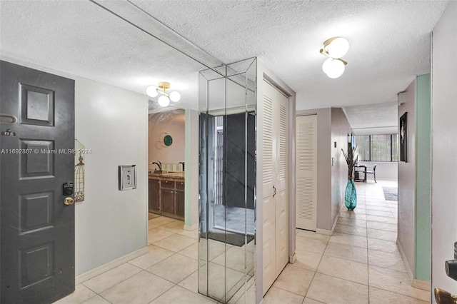 interior space with tile patterned floors, sink, and a textured ceiling