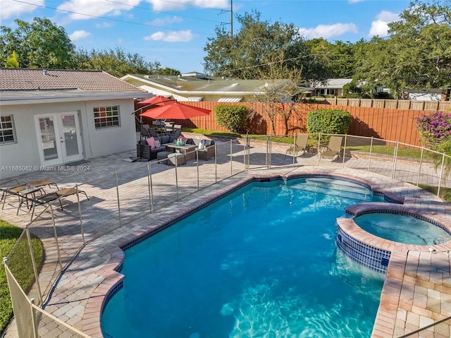 view of pool with a patio area, an in ground hot tub, and french doors