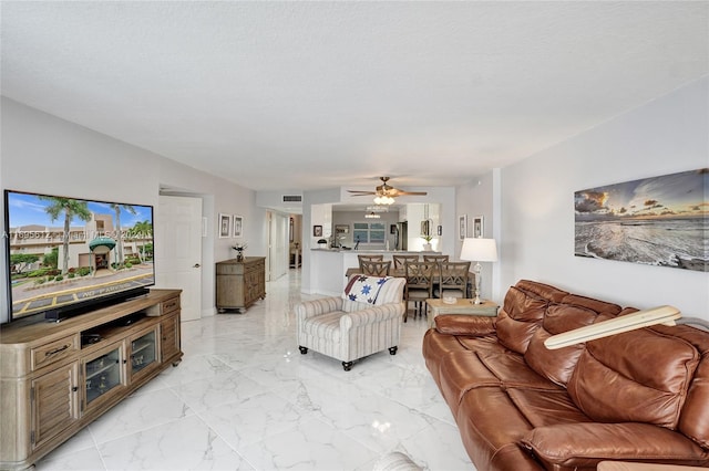 living room featuring a textured ceiling, ceiling fan, and vaulted ceiling