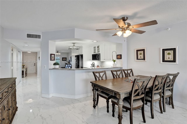 dining area featuring ceiling fan with notable chandelier and a textured ceiling