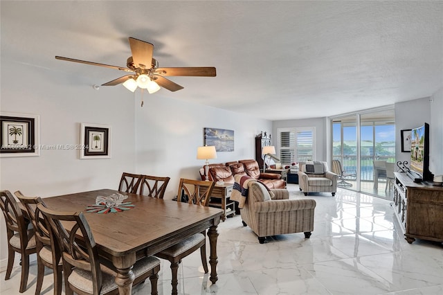 dining space featuring ceiling fan and a textured ceiling