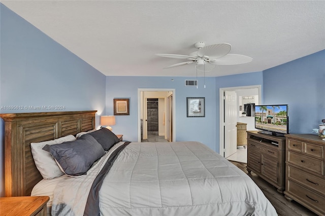 bedroom with ensuite bathroom, ceiling fan, a textured ceiling, and hardwood / wood-style flooring