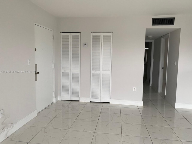 unfurnished bedroom with two closets