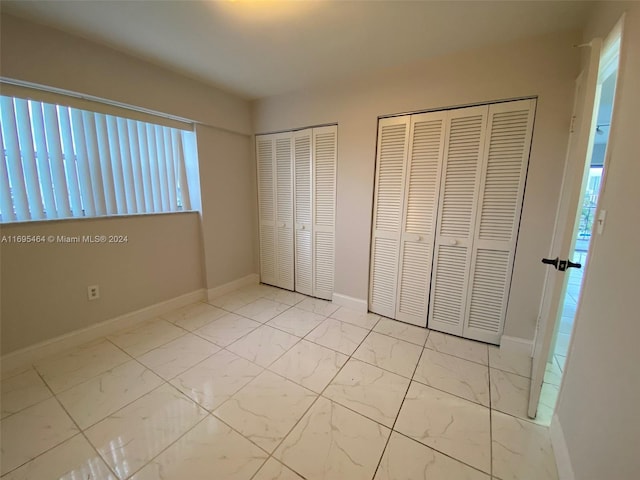 unfurnished bedroom featuring multiple closets