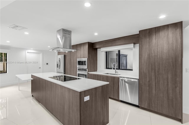 kitchen with sink, a center island, island exhaust hood, light tile patterned floors, and appliances with stainless steel finishes