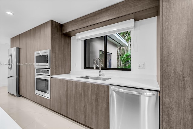 kitchen with light tile patterned floors, stainless steel appliances, and sink