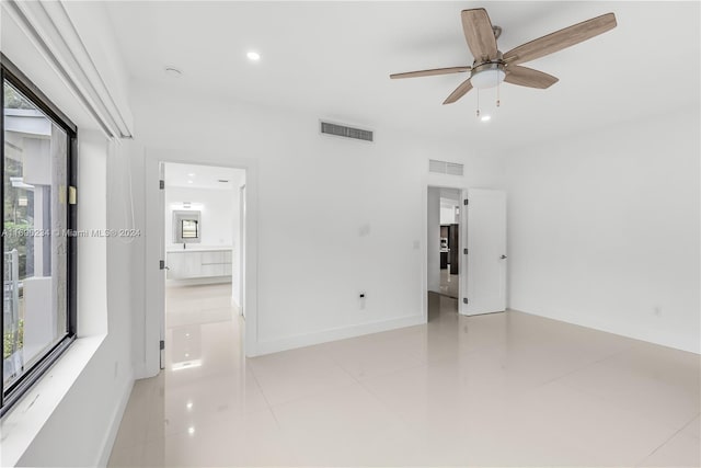 tiled empty room with ceiling fan and a healthy amount of sunlight