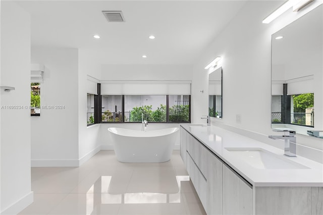 bathroom featuring a washtub, vanity, and tile patterned flooring