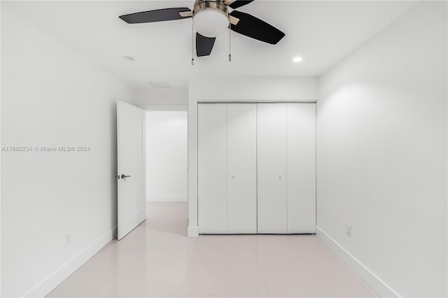 unfurnished bedroom with ceiling fan, light tile patterned flooring, and a closet