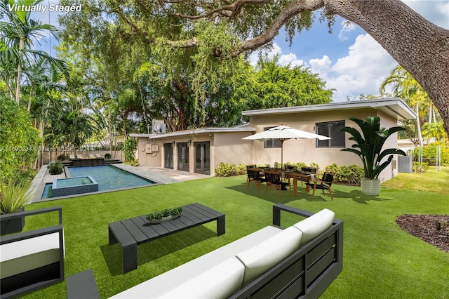 back of house featuring a lawn, an outdoor living space, and a patio area