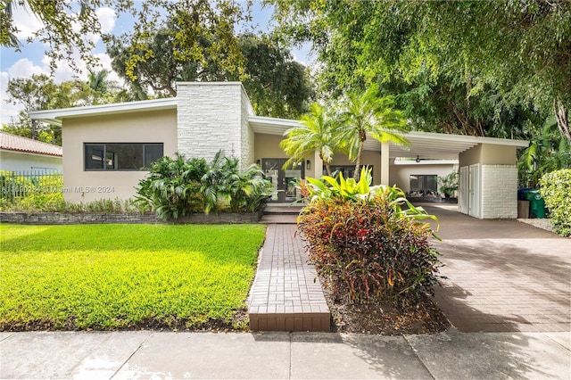 view of front of home with a front lawn and a carport