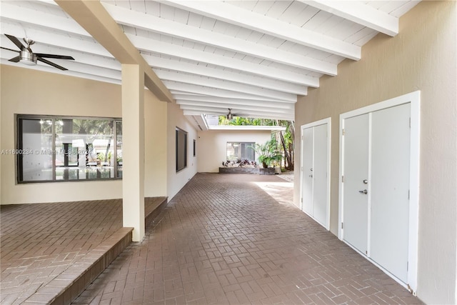 hallway with beamed ceiling and high vaulted ceiling