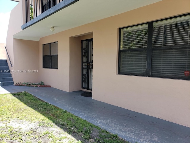 property entrance featuring a balcony and a patio