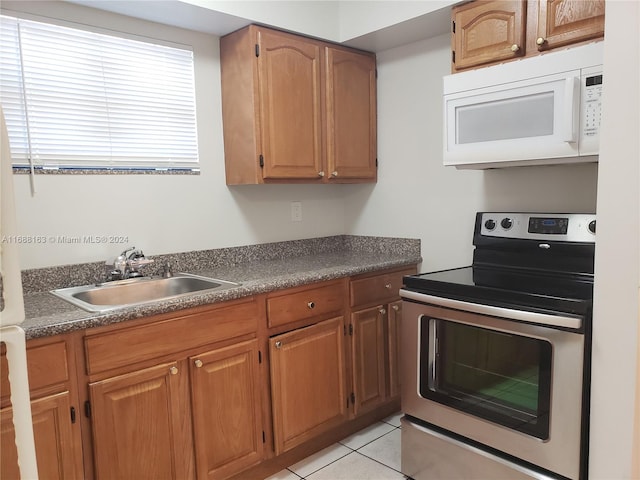 kitchen featuring light tile patterned floors, stainless steel electric range oven, and sink