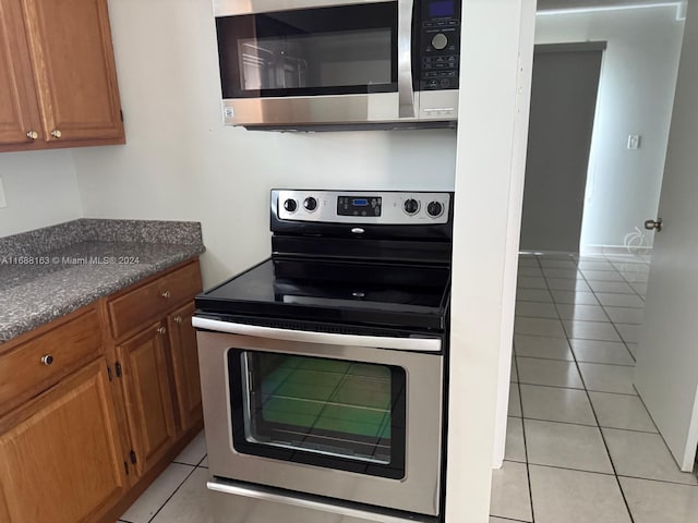 kitchen with appliances with stainless steel finishes and light tile patterned flooring